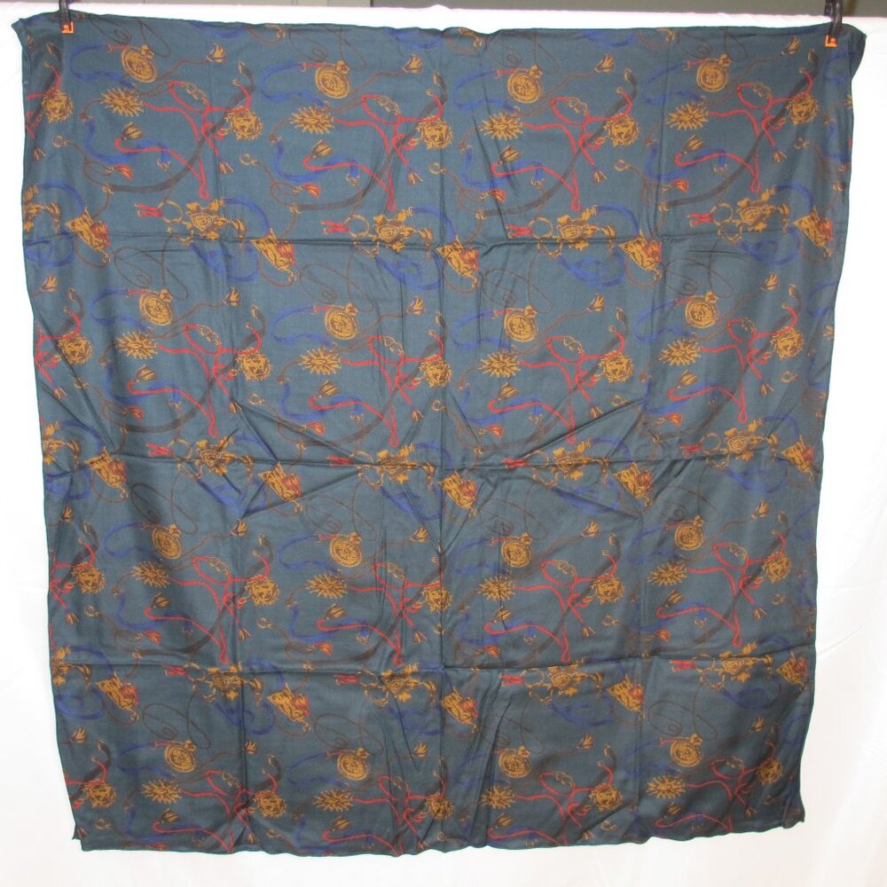 Teal green square scarf with belt pattern in blue, black, and red